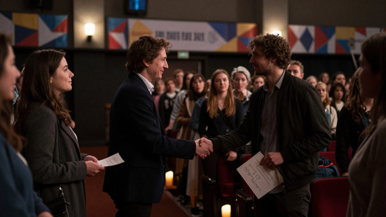 A director talking with audience members after a film screening, listening closely.