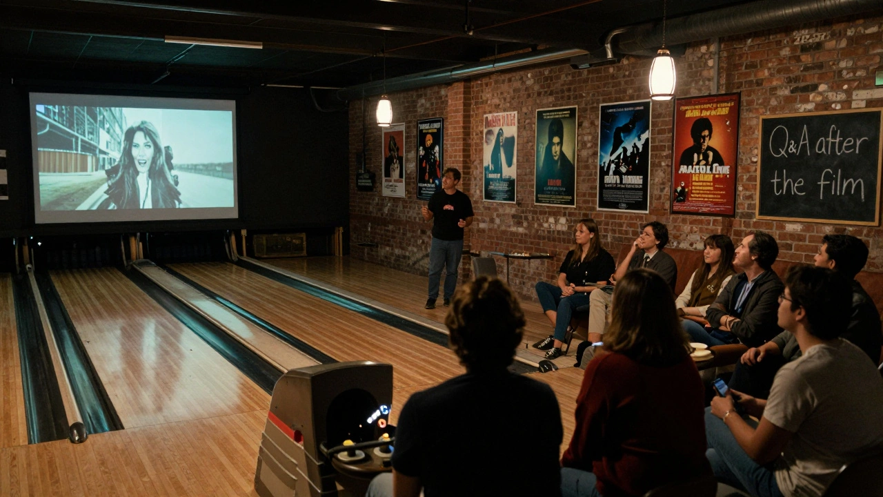 An audience watches a cult horror film in a repurposed bowling alley, with posters on the walls and a filmmaker nearby preparing for a Q&amp;A.