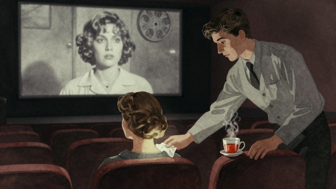 An usher offers a tissue to a viewer in a dark theater, softly lit by a film projection showing a poignant black-and-white scene.