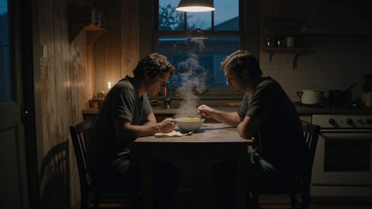 A man sits alone at a table, staring at a bowl of soup he won't eat, with an empty chair opposite him in dim candlelight.