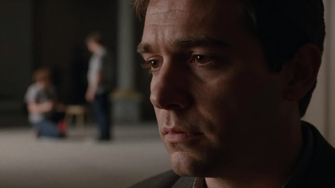 Close-up of an actor's face under moody cinematic lighting on a film set